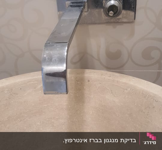 ברז מתכת מעל כיור אבן עגול